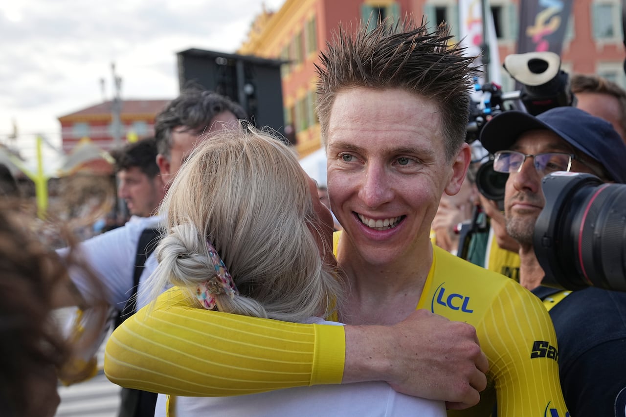 Tour de France winner Slovenia's Tadej Pogacar hugs his partner Urska Zigart after the twenty-first stage of the Tour de France cycling race, an individual time trial over 33.7 kilometers (20.9 miles) with start in Monaco and finish in Nice, France, Sunday, July 21, 2024. (AP Photo/Laurent Cipriani, Pool)