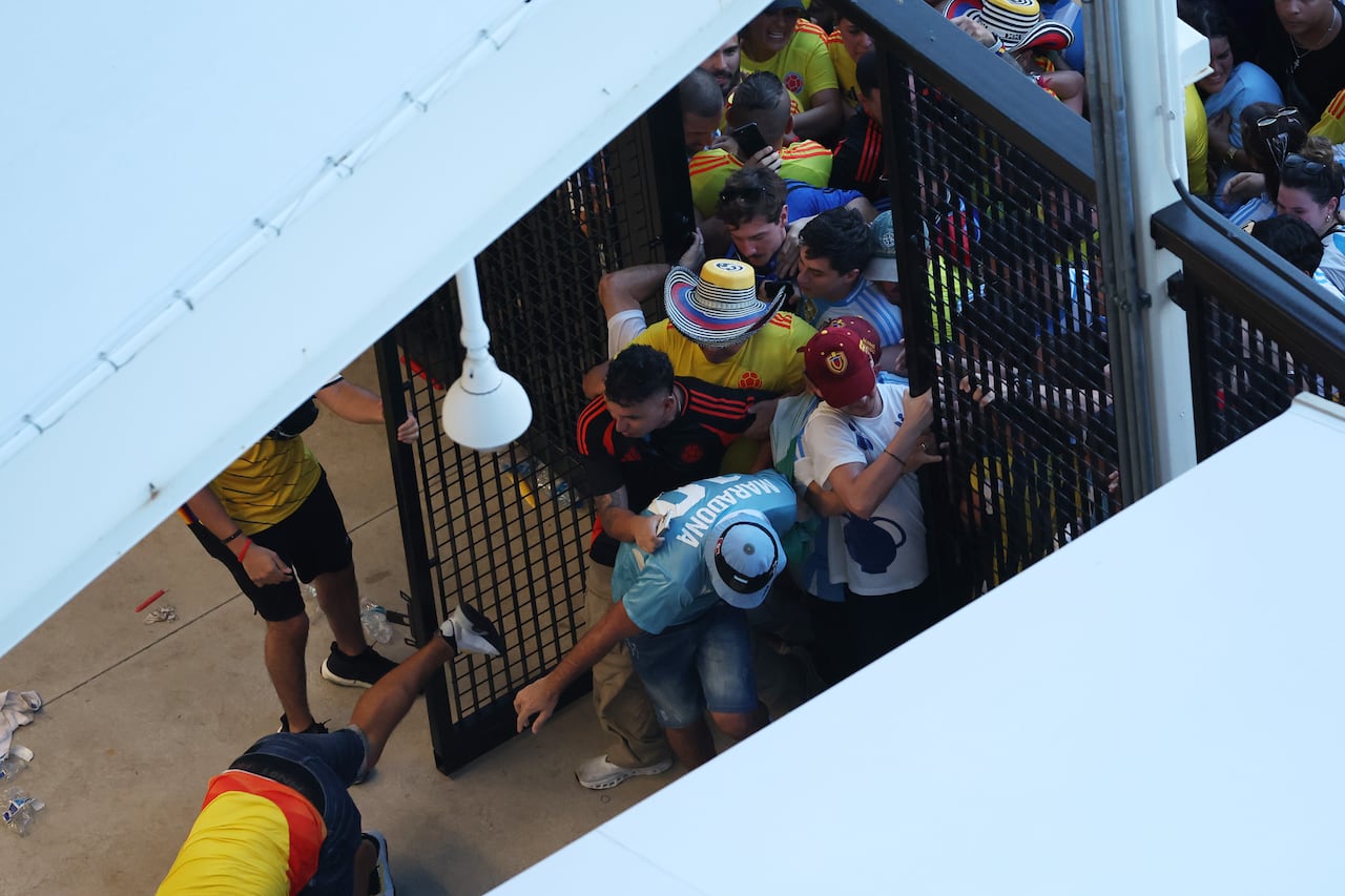 Grandes multitudes de fanáticos intentando ingresar al estadio en medio de disturbios, previos al partido final de la Copa América.