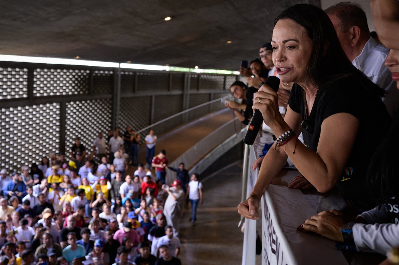 La líder de la oposición venezolana María Corina Machado habla con estudiantes junto al candidato presidencial venezolano Edmundo González (R-cubierto) durante un mitin de campaña en la Universidad Central de Venezuela en Caracas el 14 de julio de 2024.